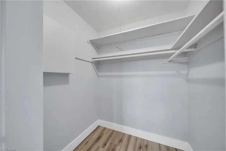 Walk in closet with light wood-style flooring