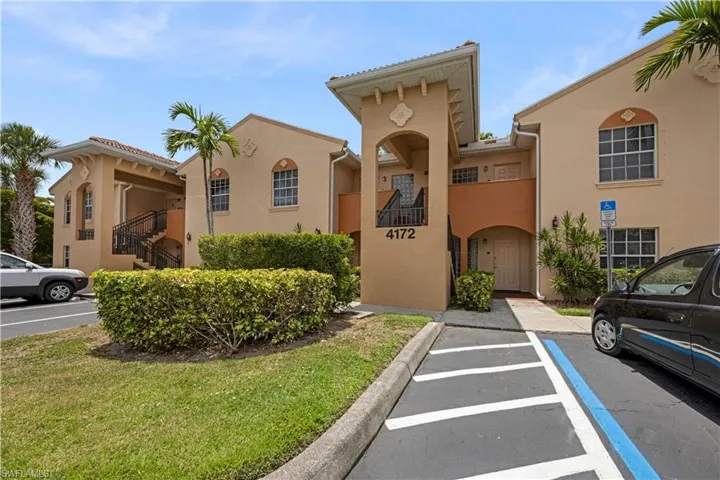 Mediterranean-inspired facade featuring stucco exterior, arched window details, and a covered entry
