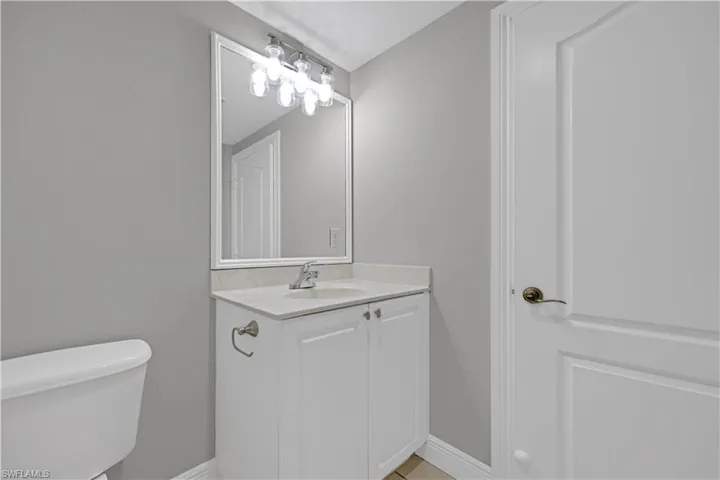 Bathroom vanity featuring a white cabinet, light-toned countertop, and undermount sink with chrome fixtures