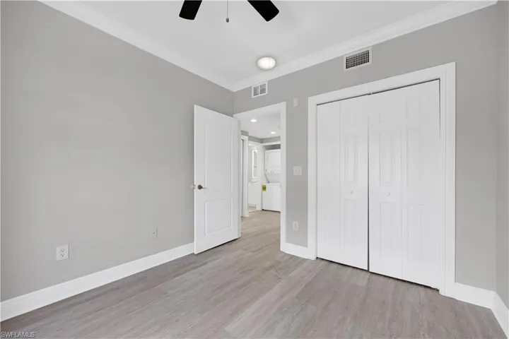 Interior room featuring wood-finish flooring, white baseboards, and a ceiling fan with integrated lighting