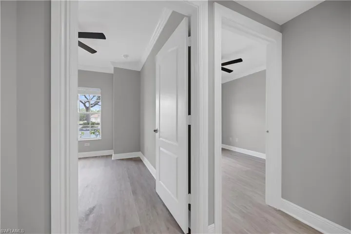 Interior hallway showcasing light gray walls and wood-finish flooring