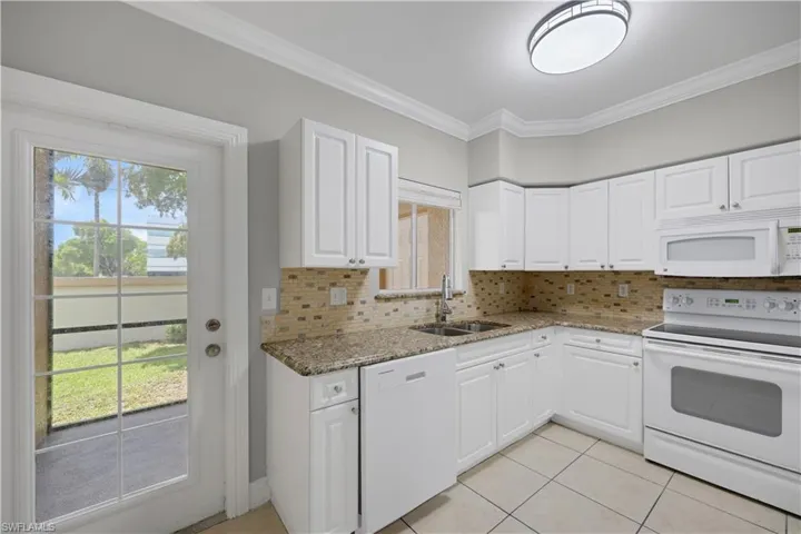 Kitchen featuring white cabinetry, granite countertops, and a tiled backsplash