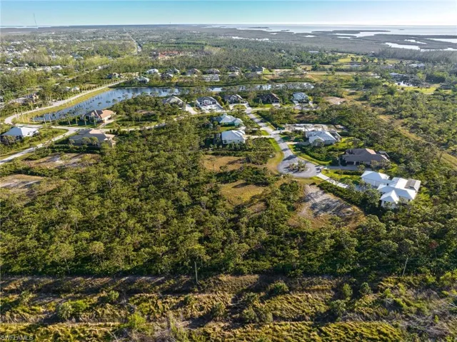 Aerial overview of property's location featuring a large body of water and nearby suburban area