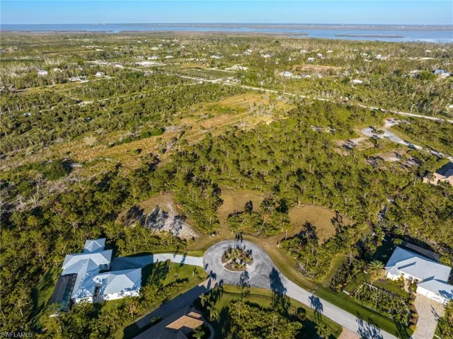 Aerial view of property and surrounding area with a nearby body of water