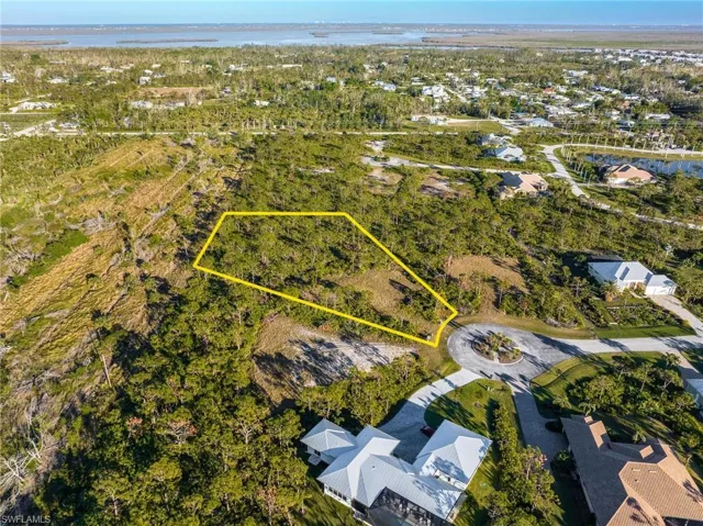 Aerial view of residential area featuring property parcel outlined and a nearby body of water