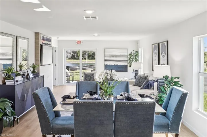 Model home. Dining room with light wood-style floors and baseboards