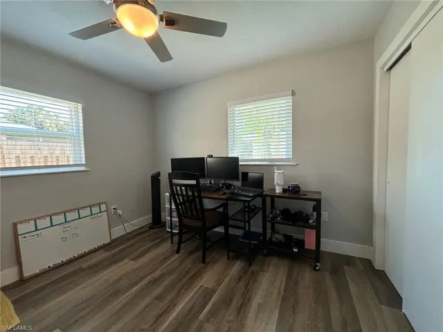 Office space with ceiling fan, dark hardwood / wood-style floors, and plenty of natural light