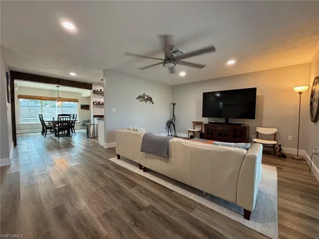 Living room with dark hardwood / wood-style floors and ceiling fan