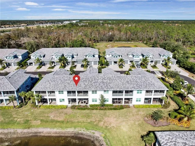 Birds eye view of property featuring a water view, a residential view, and a wooded view