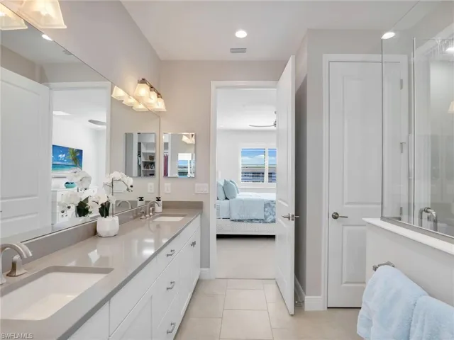 Ensuite bathroom featuring connected bathroom, tile patterned flooring, a sink, and double vanity
