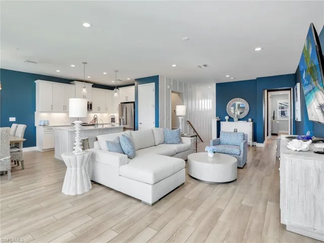 Living room featuring light wood-style floors, recessed lighting, visible vents, and baseboards
