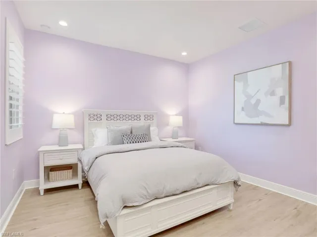 Bedroom with light wood-style flooring, visible vents, baseboards, and recessed lighting