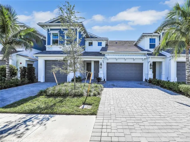 View of front facade with decorative driveway and stucco siding