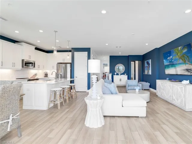 Living room with light wood finished floors, baseboards, visible vents, and recessed lighting