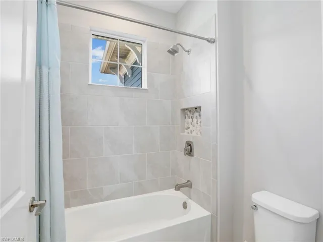 Full bathroom with shower / tub combo and toilet
