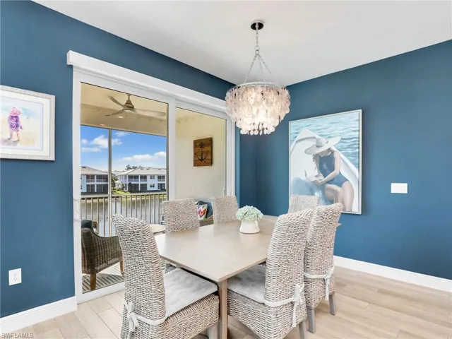 Dining room featuring baseboards, wood finished floors, and ceiling fan with notable chandelier