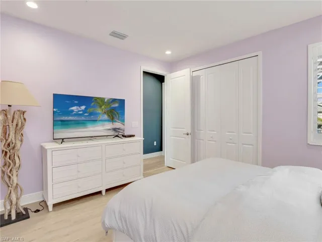 Bedroom with light wood-type flooring, baseboards, visible vents, and recessed lighting