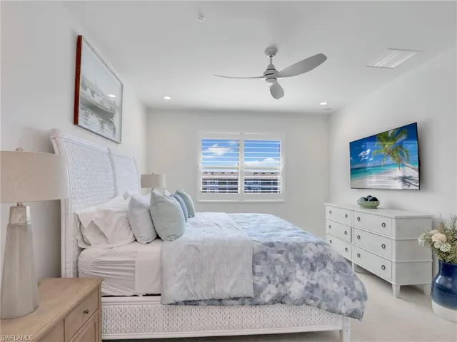 Bedroom with ceiling fan, visible vents, light colored carpet, and recessed lighting
