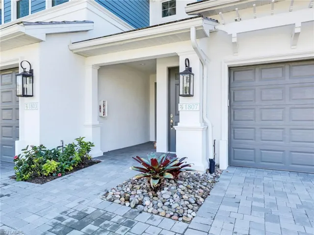 Property entrance featuring decorative driveway and stucco siding