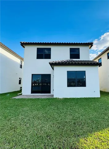 Rear view of property with a lawn
