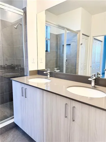 Bathroom featuring vanity and a shower with door