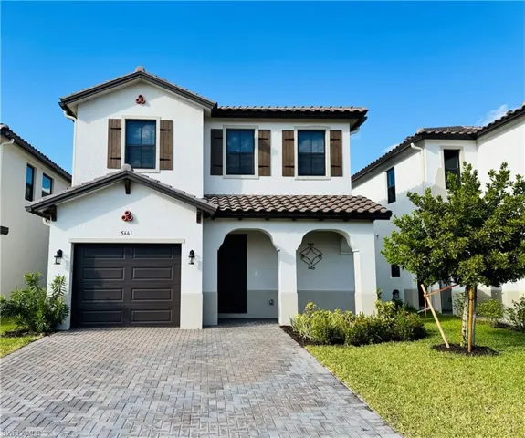 Mediterranean / spanish-style house with a front lawn and a garage
