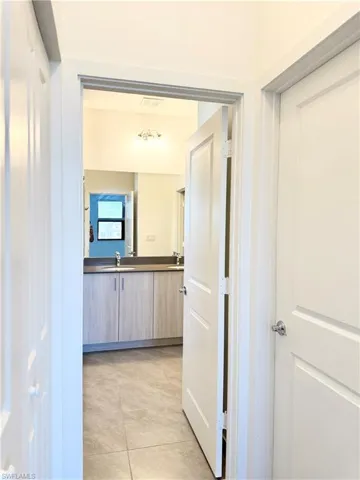 Hallway with sink and light tile patterned floors