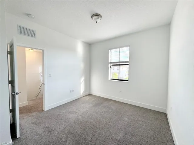 Carpeted spare room with a textured ceiling