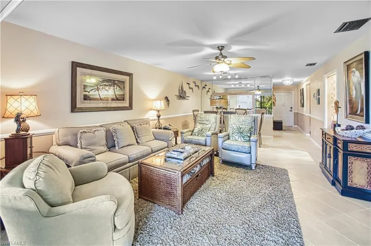 Recessed lighting with a ceiling fan, crown molding, and two-tone wall treatment
