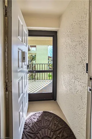 Entryway featuring a paneled door, textured wall finish, and a screened exterior door