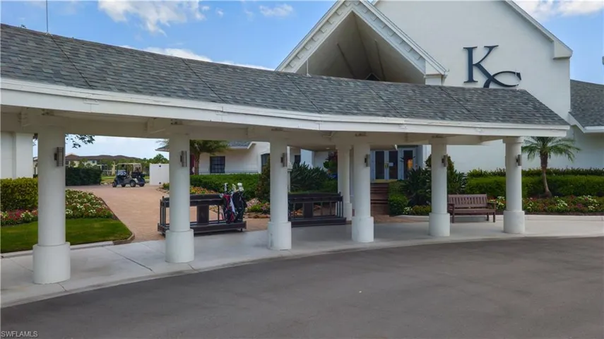 Covered entryway featuring multiple support columns, a shingled roof, and exterior wall sconces