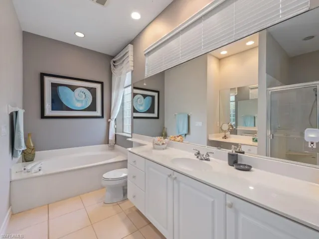 Full bathroom with tile patterned floors, separate shower and tub, vanity, and toilet