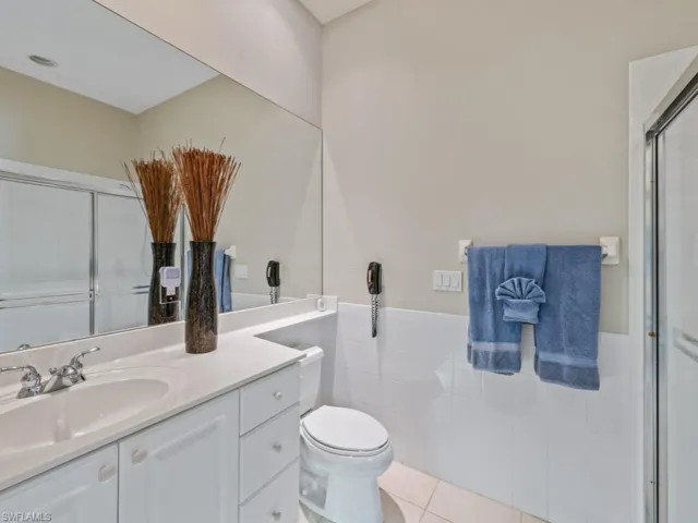Bathroom with tile patterned flooring, vanity, toilet, and an enclosed shower