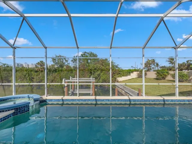 View of swimming pool featuring an in ground hot tub and glass enclosure