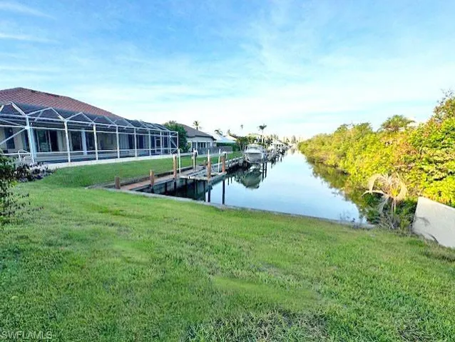 View of dock featuring a yard and a water view