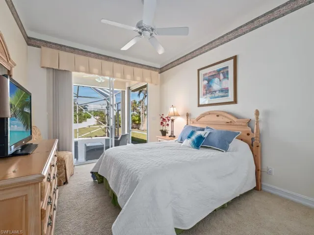 Carpeted bedroom with access to outside, ceiling fan, and crown molding
