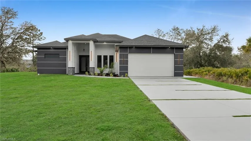 Prairie-style home featuring a front lawn and a garage