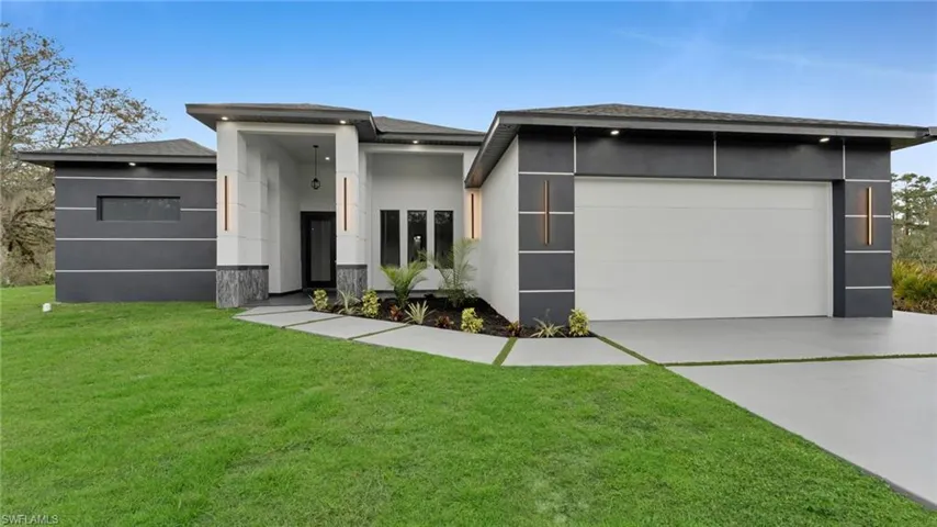 View of front of property featuring a front yard and a garage