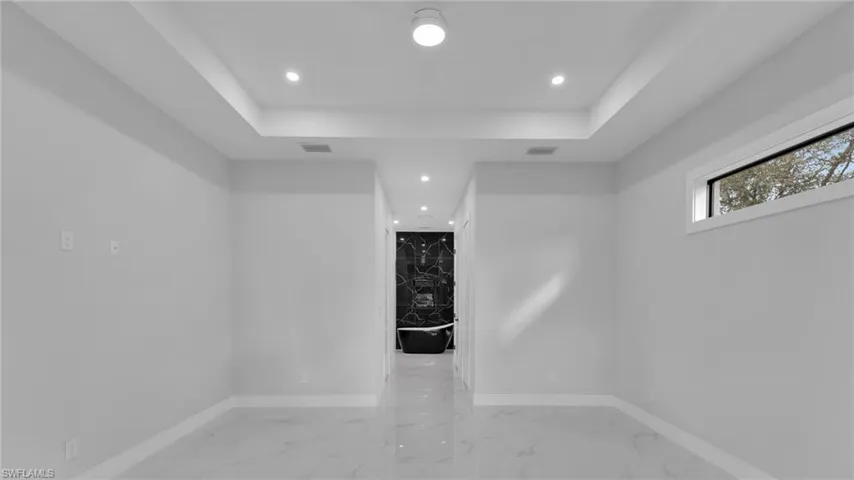 Unfurnished room with a tray ceiling