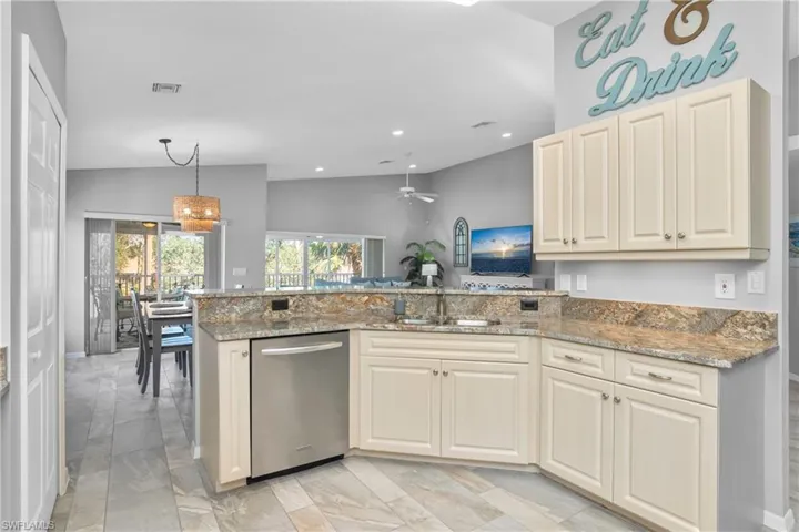 Kitchen featuring visible vents, stone counters, a peninsula, a sink, and stainless steel dishwasher