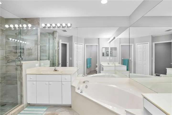 Full bathroom with toilet, a stall shower, vanity, and a garden tub