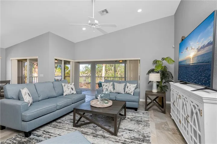 Living room featuring visible vents, high vaulted ceiling, a ceiling fan, recessed lighting, and baseboards