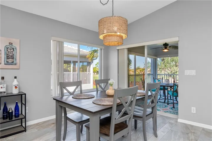 Dining space with baseboards, marble finish floor, and ceiling fan with notable chandelier