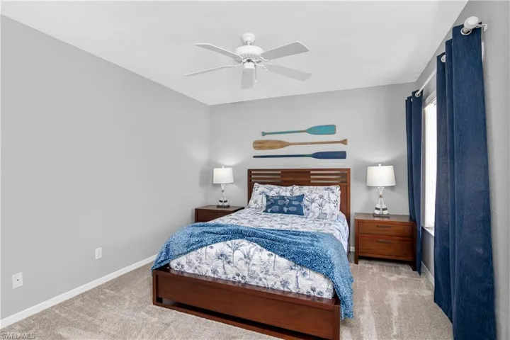 Carpeted bedroom featuring a ceiling fan and baseboards