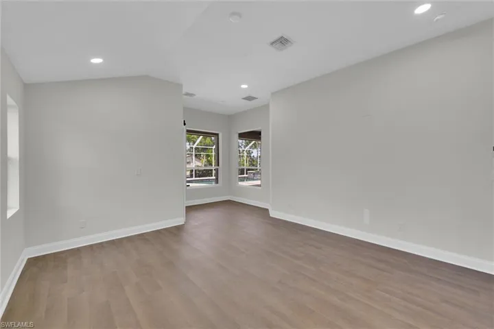 Unfurnished room with baseboards, visible vents, and wood finished floors