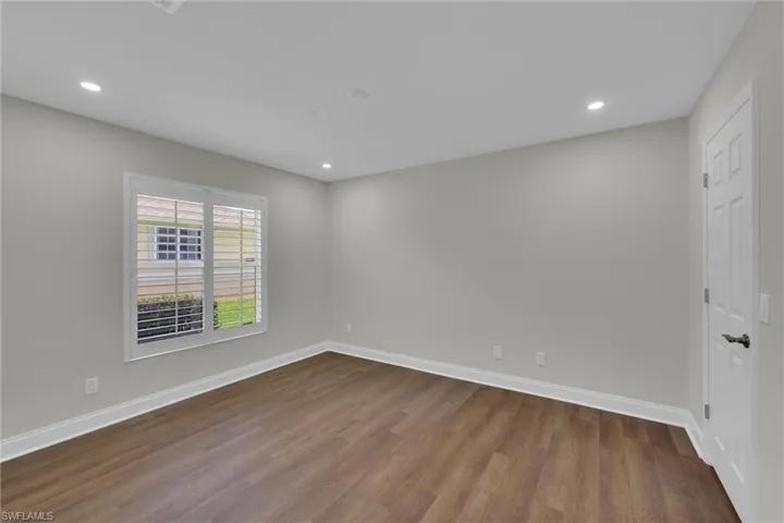 Unfurnished room with dark wood-type flooring, baseboards, and recessed lighting
