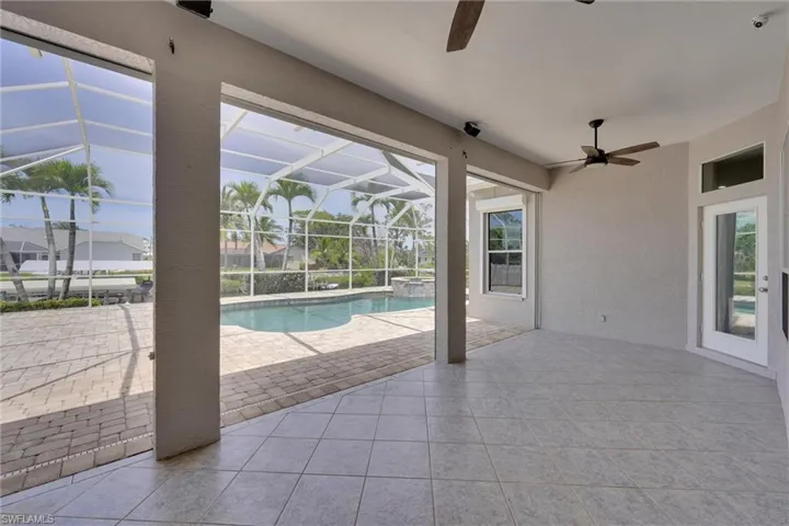 View of pool featuring a pool with connected hot tub, a lanai, a patio, and a ceiling fan