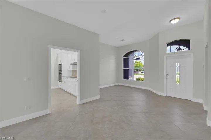 Entryway with light tile patterned floors and baseboards