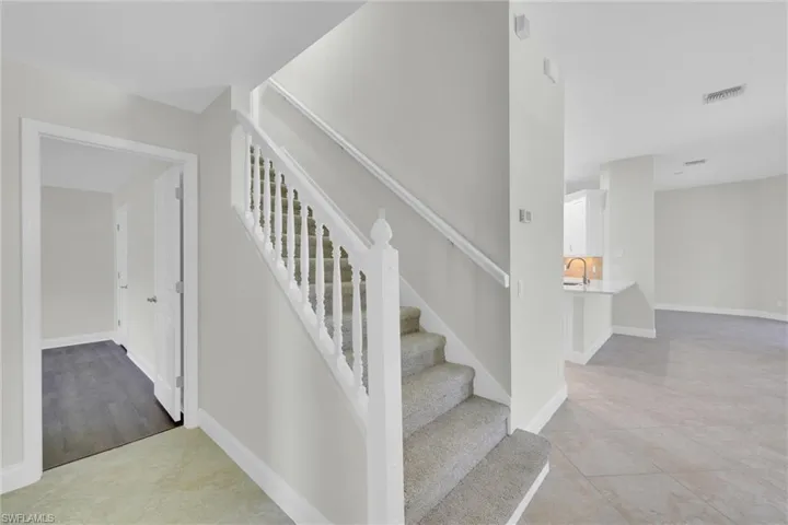 Stairs with visible vents and baseboards