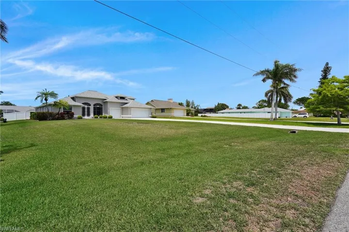 View of yard featuring concrete driveway and a garage